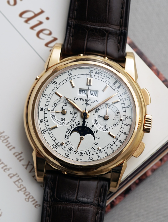 Patek Philippe 5970 perpetual calendar chronograph in yellow gold, resting on an old French book